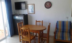 a dining room with a table and chairs and a clock at Apartment in Las Americas in Playa de las Americas