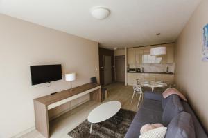 a living room with a blue couch and a table at VacationClub - BORMIO Apartament 17 in Sienna
