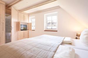 a white bedroom with a bed and a window at Family&Friends in Wyk auf Föhr