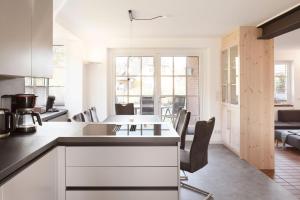 a kitchen and living room with a table and chairs at Family&Friends in Wyk auf Föhr +16 photos