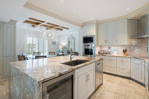 a kitchen with white cabinets and a marble counter top at Starfish Legacy villa by Peace Vacations in Georgetown
