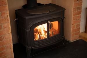 a black fireplace with a fire in it at The Old School Historic Stay for 2 Adelaide Hills in Balhannah