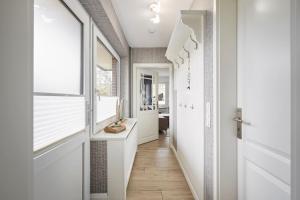 a hallway with white walls and a white door at Wiesenglück in Wyk auf Föhr