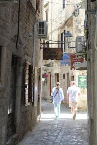 two people walking down a street in an alley at Mala Porta in Trogir