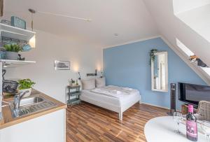 a small living room with a bed and a sink at fewo1846 - Strandresidenz Wassersleben AHOI - strandnahes Studioapartment im Dachgeschoss in Harrislee
