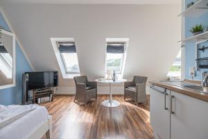 a living room with a table and chairs and a tv at fewo1846 - Strandresidenz Wassersleben AHOI - strandnahes Studioapartment im Dachgeschoss in Harrislee