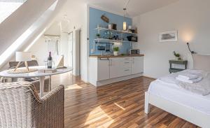 a room with a bed and a table and a kitchen at fewo1846 - Strandresidenz Wassersleben AHOI - strandnahes Studioapartment im Dachgeschoss in Harrislee