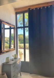 a room with a blue curtain and a table and a window at Mas des Branches d'Or in Cavaillon