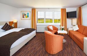 een hotelkamer met een bed en een bank bij Seemöwe Swiss Quality Hotel in Güttingen