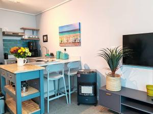 a kitchen with a blue island in a room at Wavescapes Tides Stay in Muizenberg