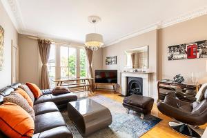 a living room with a couch and a fireplace at Super Chic 1-Bedroom Urban Hideaway in Twickenham +27 photos
