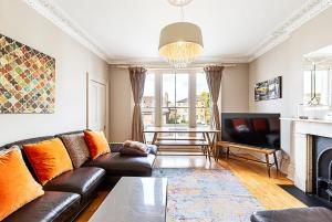 a living room with a couch and a fireplace at Super Chic 1-Bedroom Urban Hideaway in Twickenham