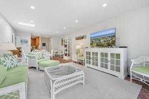 Una sala de estar con muebles blancos y un televisor. en Waters Edge villa by Peace Vacations, en Georgetown