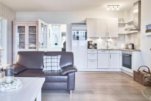 a living room with a couch and a kitchen at Haus Leuchtfeuer 4 in Wyk auf Föhr