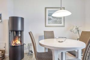 a living room with a table with a ethanol fireplace at Haus Leuchtfeuer 4 in Wyk auf Föhr