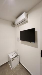 a white room with a tv on the wall at Manaira Suite 03 in João Pessoa