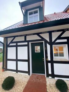a carriage house with a green garage door at DRIEHOF LifeStyle Classic Apt 5 in Tecklenburg