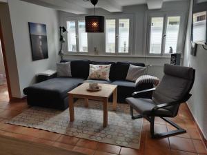 a living room with a couch and a chair at Ferienhaus Salamander inkl Sauna in Wildemann