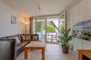 a living room with a couch and a table at Schloss am Meer 9 in Wyk auf Föhr +19 photos