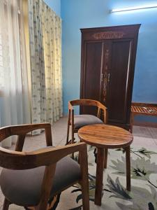 ジャイプールにあるGullu Kuku Homestayの椅子2脚、テーブル1台、ドア1台が備わるお部屋