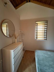 a bedroom with a dresser and a mirror at Salitzo Apartment Palairos in Paleros +3 photos