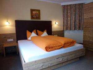 a bedroom with a bed with an orange comforter at Apart Heidi in See