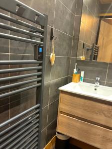 een badkamer met een wastafel en een spiegel bij RPP C213 - Charmant appt 4pers-Ski aux pieds in Tignes
