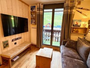 een woonkamer met een bank en een groot raam bij RPP C213 - Charmant appt 4pers-Ski aux pieds in Tignes