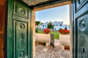 an open door with a view of a house at Masseria Luco in Martina Franca