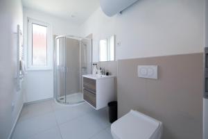 a white bathroom with a shower and a toilet at Villa Oliver Kehidakustány in Kehidakustány +42 photos