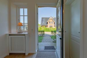 an open door with a view of a house at Stine Marie 1 in Borgsum