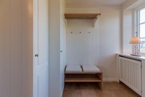 a room with a closet with a bench and a window at Stine Marie 1 in Borgsum +30 photos
