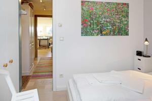 a bedroom with a painting of flowers on the wall at Luv in List +8 photos