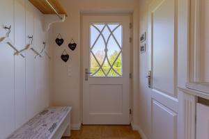 a hallway with a white door and a window at Stine Marie 2 in Borgsum