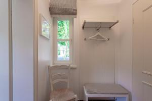 a small room with a chair and a window at Antje's Hus in Wyk auf Föhr