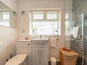 a bathroom with a sink and a toilet and a window at Silverdale Secret Gem with Private Garden Pass the Keys in Newcastle under Lyme +13 photos