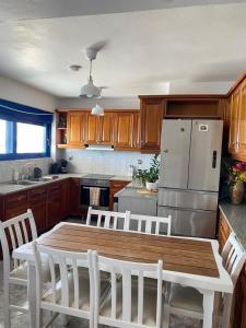 a kitchen with a wooden table and a refrigerator at Porto Mare Apartment in Elafonisos +18 photos