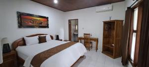 een slaapkamer met een groot wit bed in een kamer bij Serongga guest house in Lebih