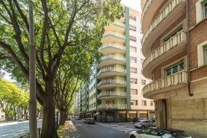Un edificio de apartamentos con coches aparcados en una calle. en Appartamento Green House, en Turín