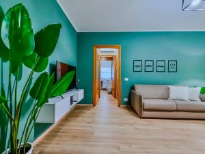 a living room with a couch and a plant at Deluxe Apartment Business Ready Free Parking in Abano Terme +18 photos
