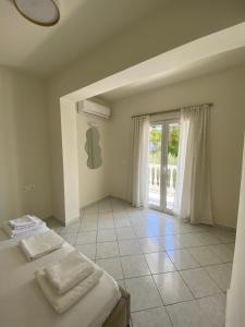 a bedroom with two beds and a large window at White Lotus Loft & Apartments in Laganas +44 photos