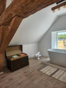 een badkamer op zolder met een bad en een raam bij La suite signature in Maisonnais