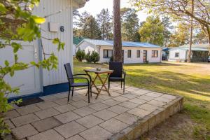 a patio with two chairs and a table next to a building at Ferienanlage Zum Knirk in Lubmin