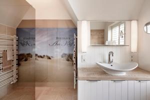een badkamer met wastafel en douche bij Reethaus Am Kliff in Goting