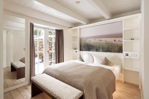 een slaapkamer met een bed met een schilderij aan de muur bij Reethaus Am Kliff in Goting