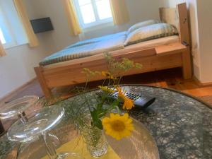a table with a vase with flowers on it with a bed at Loensches Gut in Görlitz