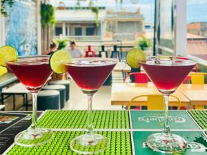 three martini glasses sitting on a table with a drink at THE PLACE Hostel Battambang in Battambang +27 photos