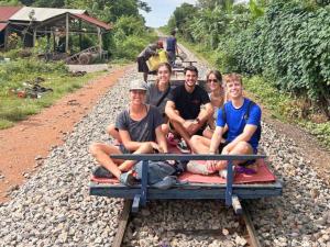 a group of people sitting on a train track at THE PLACE Hostel Battambang in Battambang