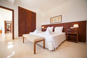 a bedroom with a large white bed and a table at Stunning Modern Ibiza Villa with Private Pool,1252 in Cala Vadella +55 photos