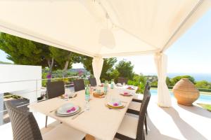 a white tent with a table and chairs on a patio at Stunning Modern Ibiza Villa with Private Pool,1252 in Cala Vadella
